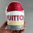 Tênis LV Trainer branco violeta da Louis Vuitton com detalhe vermelho e sola cinza segurado por mão