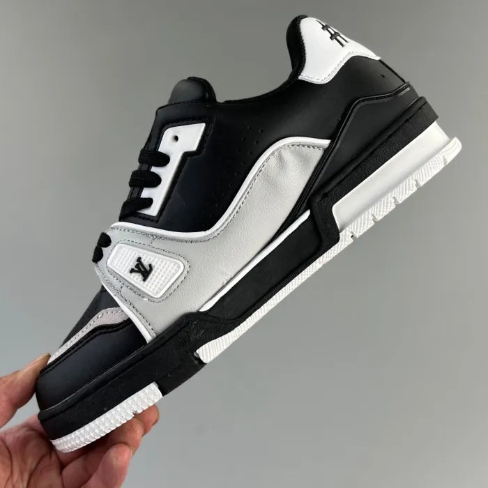 Tênis LV Trainer preto cinza estilo casual com design moderno segurado por uma mão